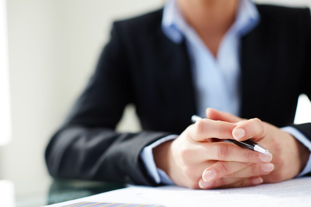 Profesional del derecho en despacho durante una consulta legal con documentación sobre la mesa.